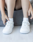 Zapatilla escolar barefoot blanca modelo Retro con velcro para kids en uso vista frontal