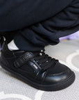 Zapatilla escolar barefoot negra modelo Dune con velcro para kids en uso detalle ajuste velcro