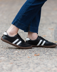Zapatilla barefoot ergonomica negro modelo Terra para adultos vista lateral en uso