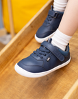 Zapatilla escolar barefoot azul marino modelo Dash con doble velcro para toddler en uso vista lateral
