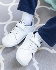 Zapatilla escolar barefoot blanca modelo Dune con velcro para kids en uso vista superior sentado