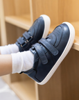 Zapatilla escolar barefoot azul marino modelo Vintage con doble velcro para toddler en uso vista lateral