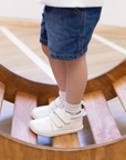 Zapatilla escolar barefoot blanca modelo Rain media caña para toddler en uso sobre tabla equilibrio