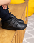 Zapatilla escolar barefoot negra modelo Rain media caña para toddler en uso vista lateral