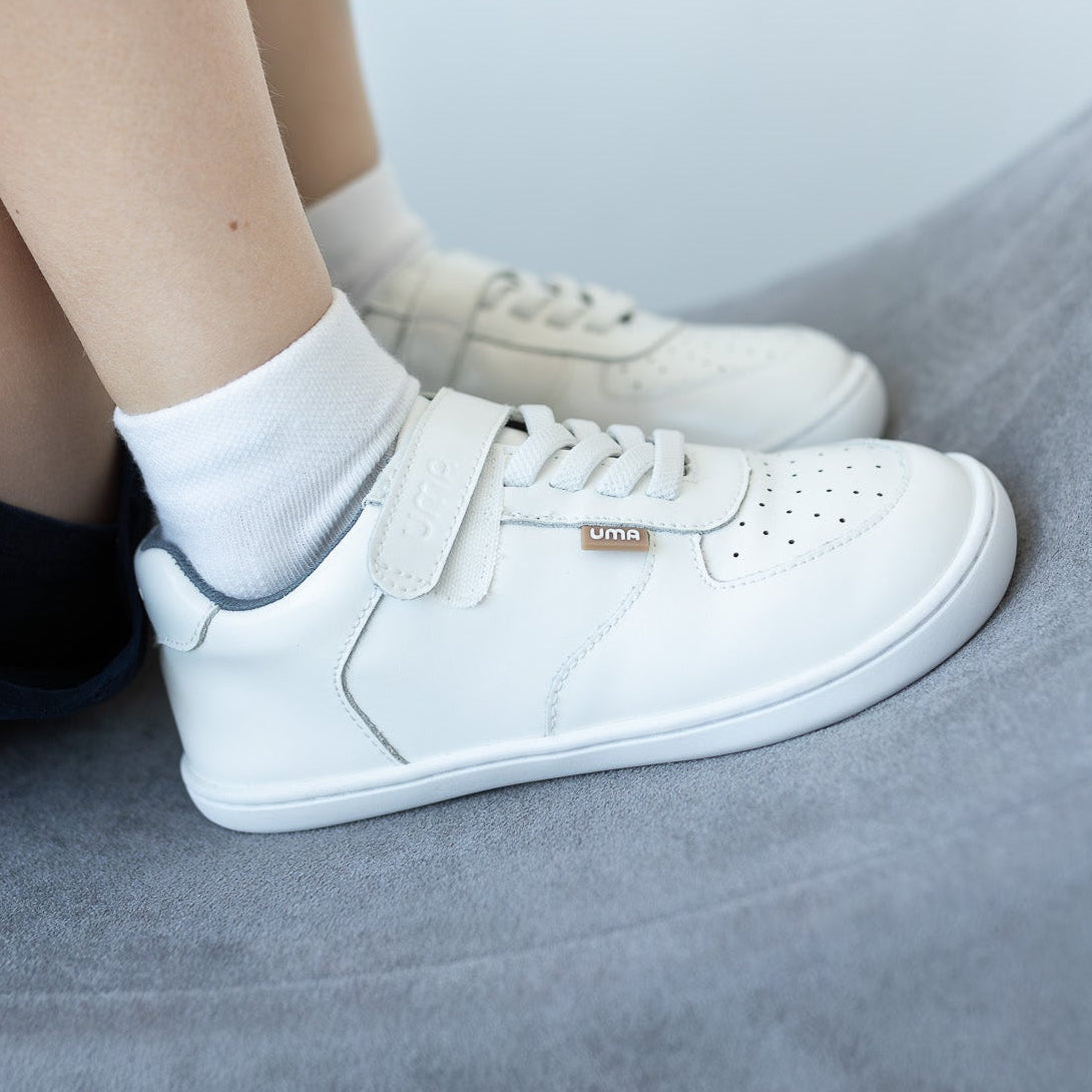 Zapatilla escolar barefoot blanca modelo Retro con velcro para kids en uso vista lateral
