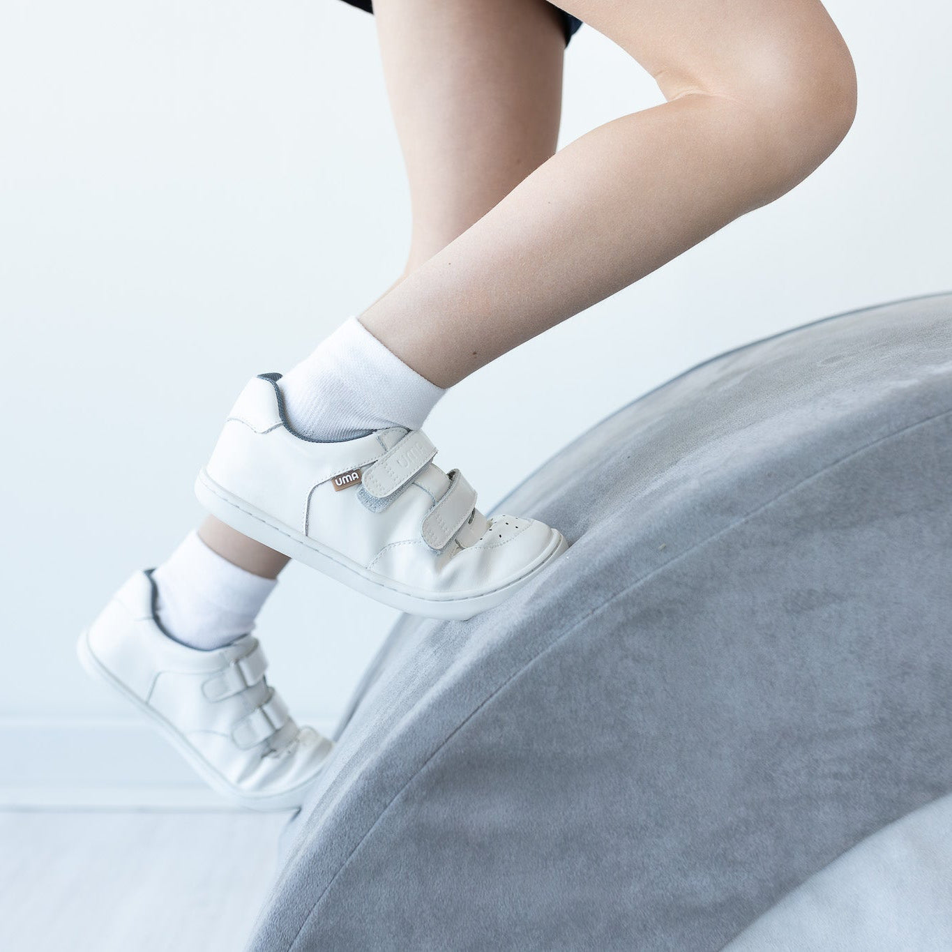 Zapatilla escolar barefoot blanca modelo Vintage con doble velcro para kids en uso vista lateral
