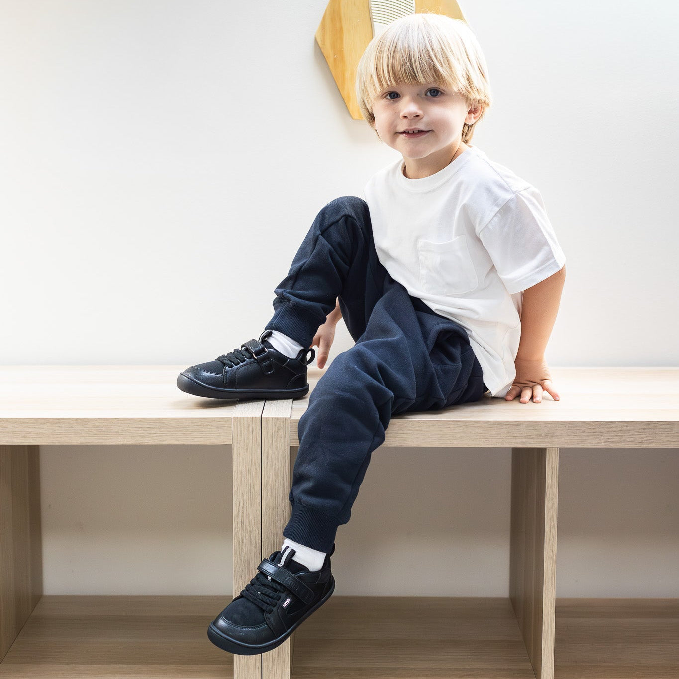 Zapatilla escolar barefoot negra modelo Dune con velcro para kids en uso niño sentado
