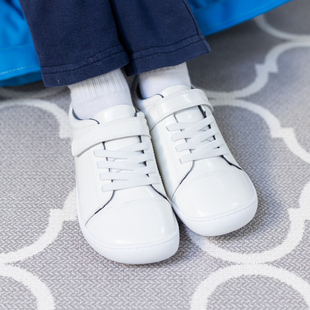 Zapatilla escolar barefoot blanca modelo Cloud con elásticos para kids en uso vista superior
