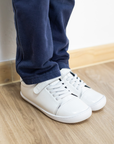 Zapatilla escolar barefoot blanca modelo Cloud con elásticos para kids en uso vista frontal
