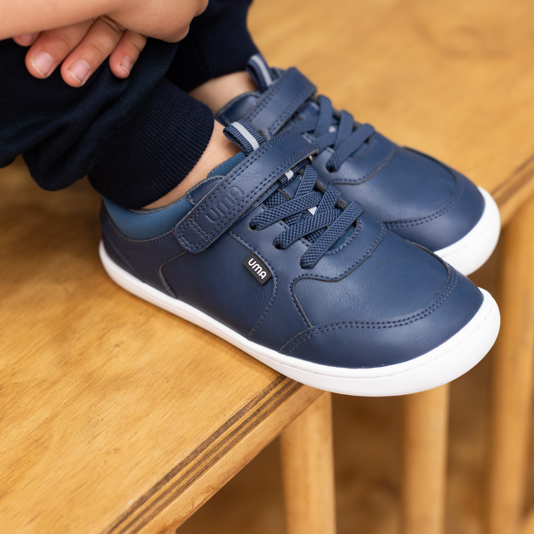 Zapatilla escolar barefoot azul marino modelo Dash con doble velcro para kids en uso semi frontal

