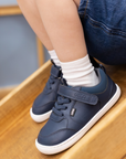 Zapatilla escolar barefoot azul marino modelo Dash con doble velcro para toddler en uso calzando
