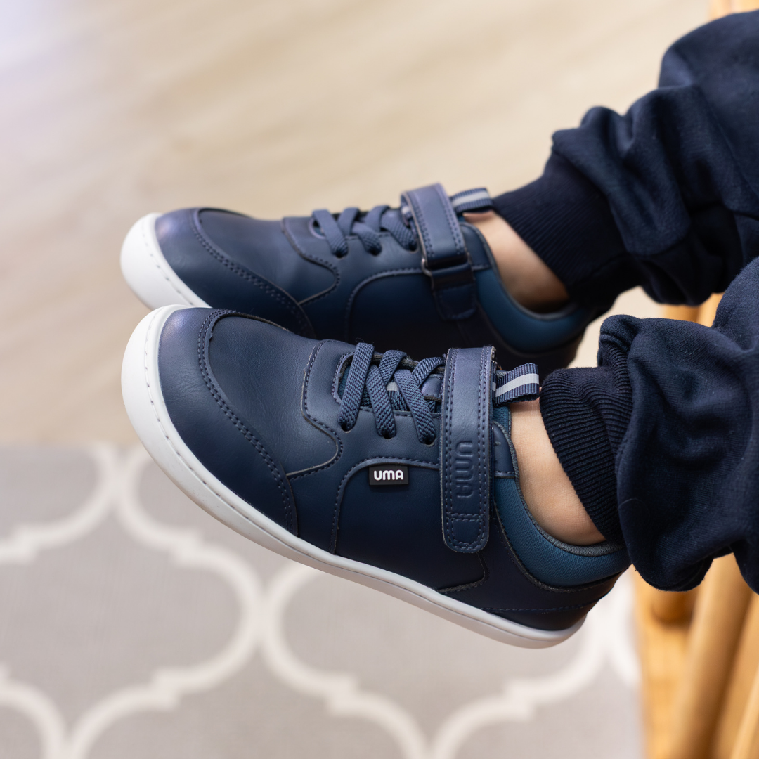 Zapatilla escolar barefoot azul marino modelo Dash con doble velcro para kids en uso vista lateral
