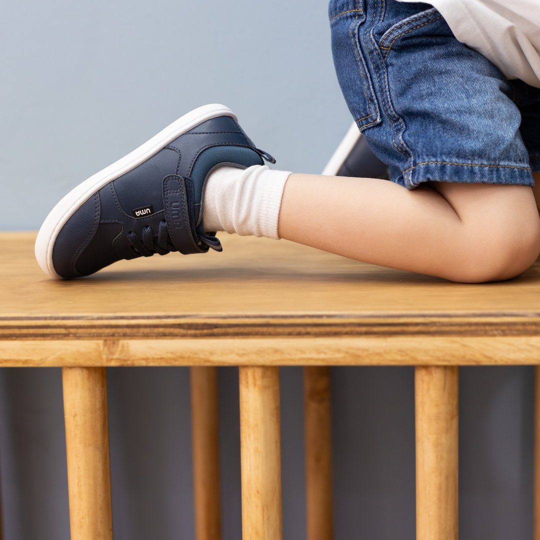 Zapatilla escolar barefoot azul marino modelo Dash con doble velcro para toddler en uso arrodillado
