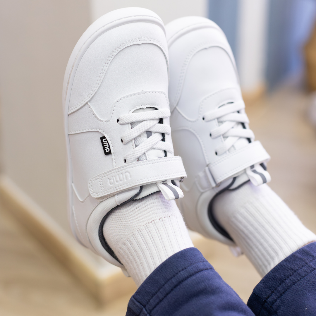 Zapatilla escolar barefoot blanca modelo Dash con doble velcro para toddler en uso vista lateral 
