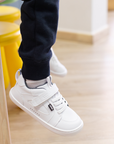 Zapatilla escolar barefoot blanca modelo Dune con velcro para kids en uso vista lateral 
