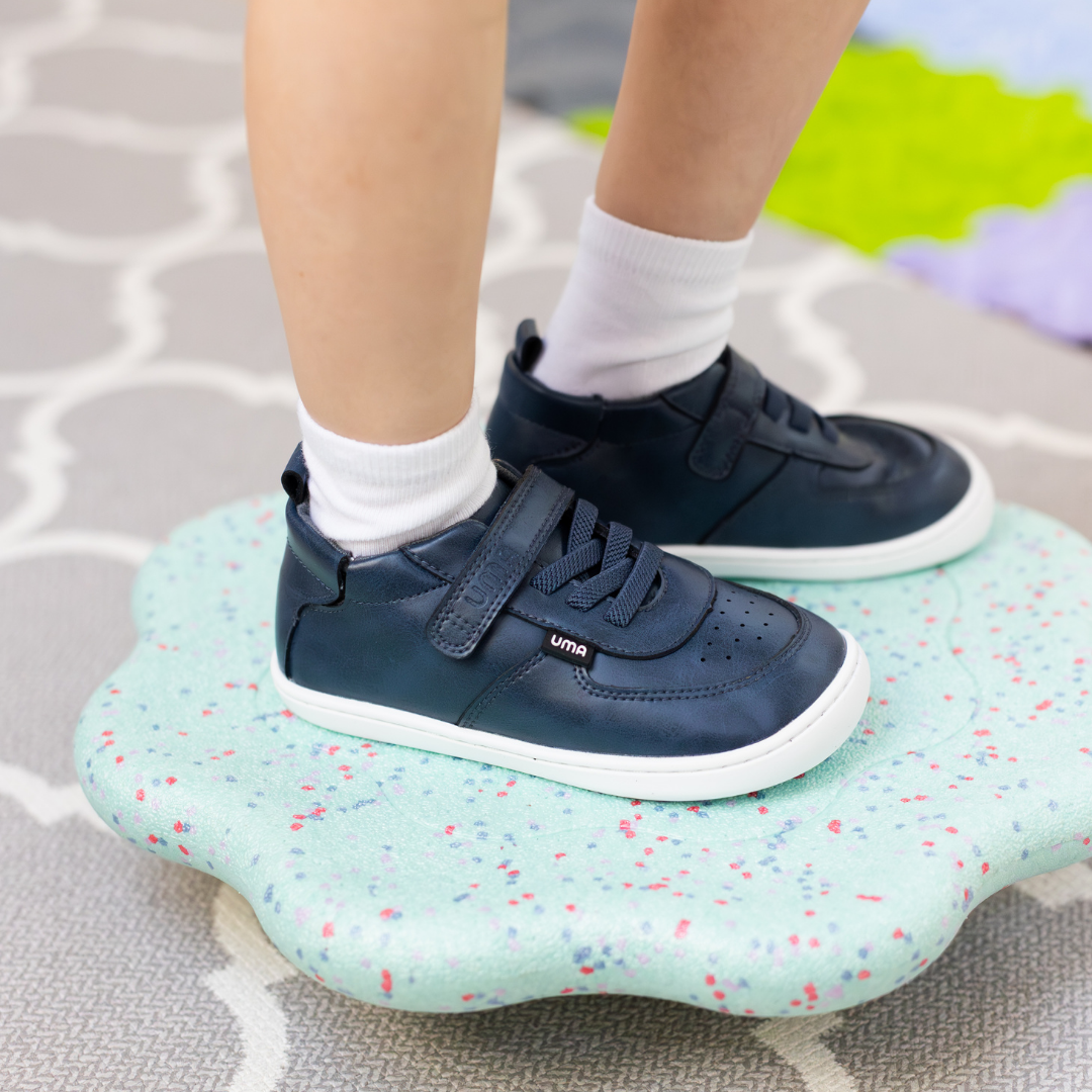 Zapatilla escolar barefoot azul marino modelo Retro con velcro para toddler en uso vista semi frontal
