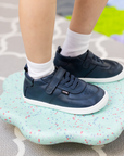 Zapatilla escolar barefoot azul marino modelo Retro con velcro para toddler en uso vista semi frontal
