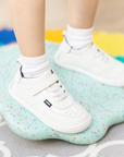 Zapatilla escolar barefoot blanca modelo Retro con velcro para toddler en uso vista lateral

