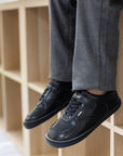 Zapatilla escolar barefoot negra modelo Retro con velcro para kids en uso vista lateral
