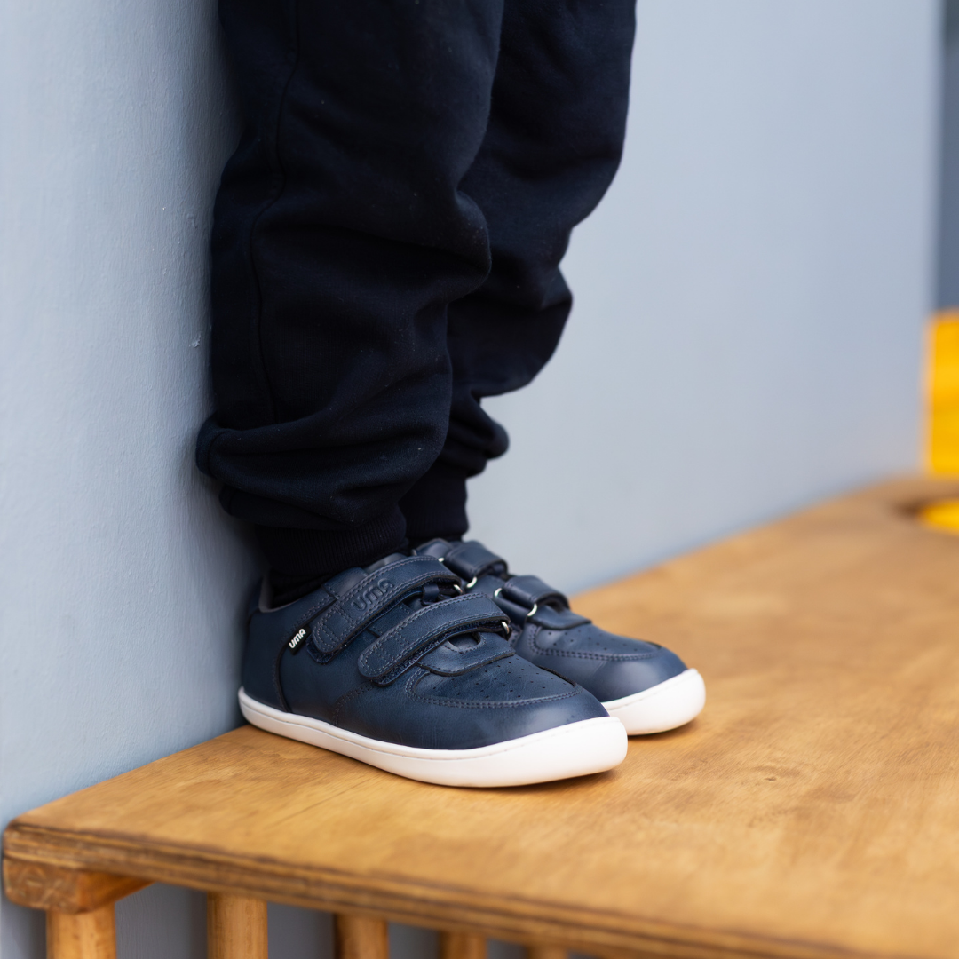 Zapatilla escolar barefoot azul marino modelo Vintage con doble velcro para kids en uso vista lateral calzando
