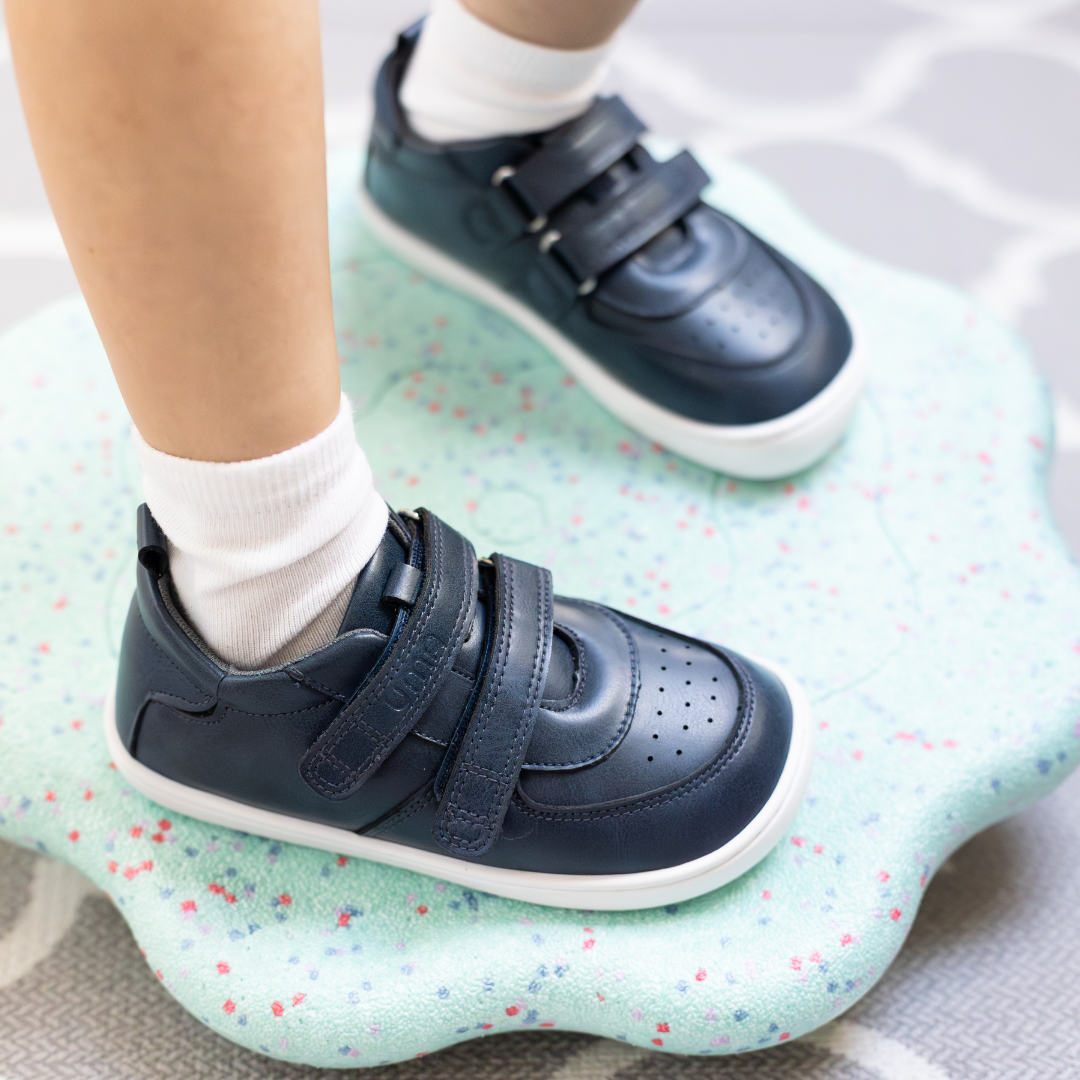 Zapatilla escolar barefoot azul marino modelo Vintage con doble velcro para toddler en uso vista superior lateral
