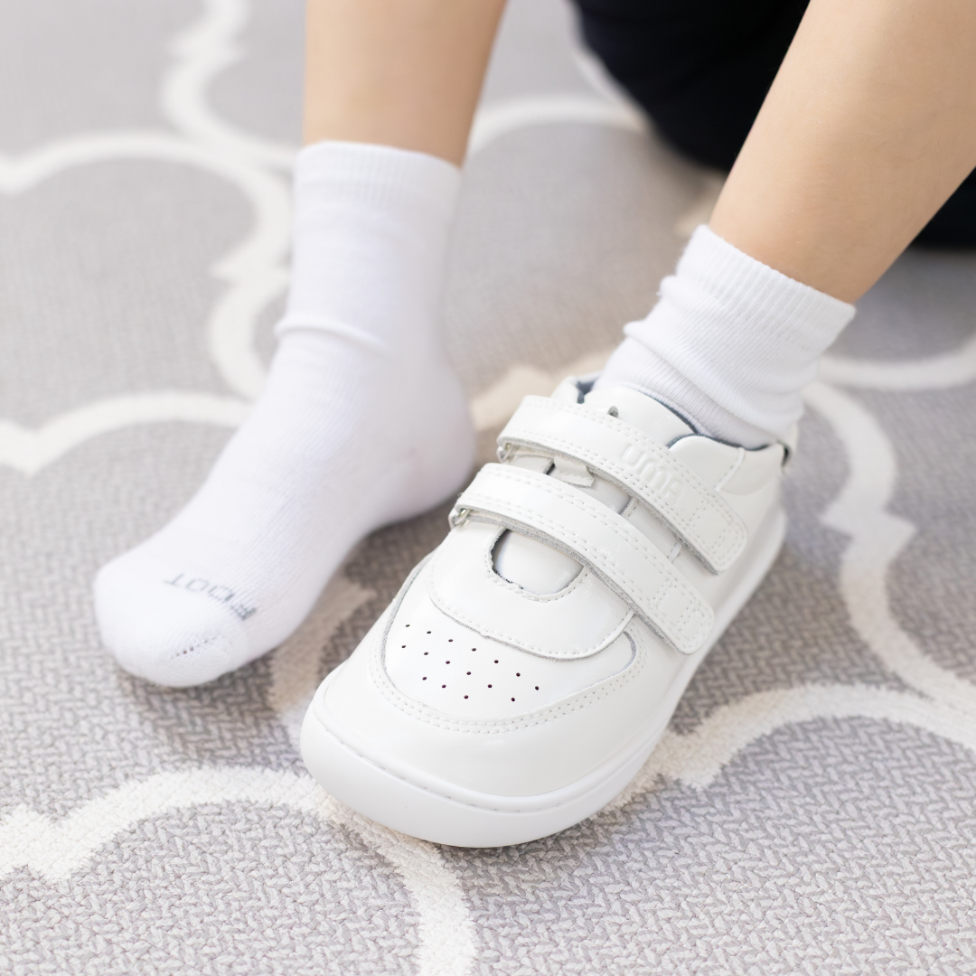 Zapatilla escolar barefoot blanca modelo Vintage con doble velcro para toddler en uso vista frontal superior
