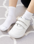 Zapatilla escolar barefoot blanca modelo Vintage con doble velcro para toddler en uso vista frontal superior
