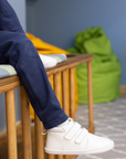 Zapatilla escolar barefoot blanca modelo Rain media caña para kids en uso vista lateral sentado