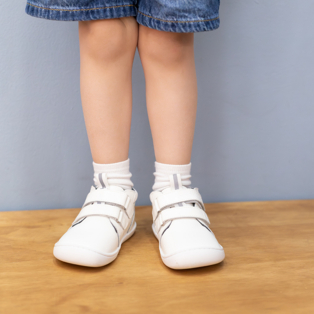 Zapatilla escolar barefoot blanca modelo Rain media caña para toddler en uso vista frontal
