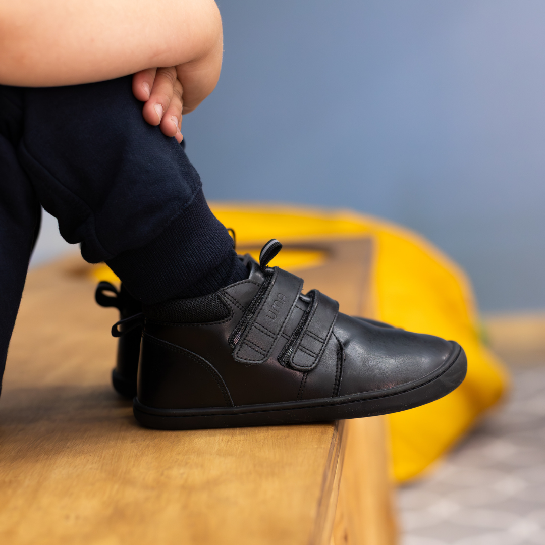 Zapatilla escolar barefoot negra modelo Rain media caña para kids en uso calzando