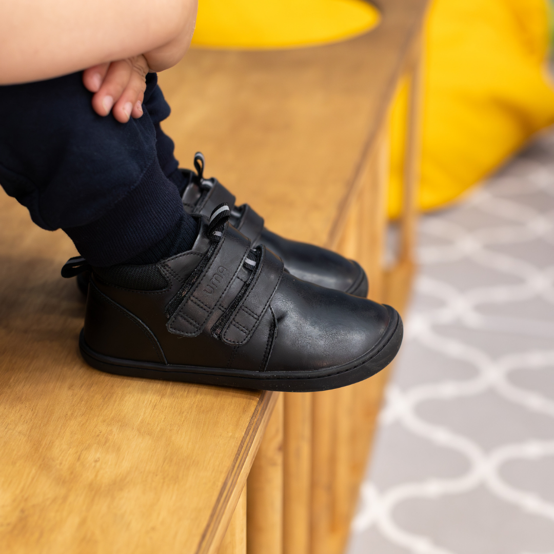Zapatilla escolar barefoot negra modelo Rain media caña para kids en uso vista lateral