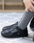 Zapato escolar barefoot negro modelo T-Bar con correa velcro para niña kids en uso detalle ajuste
